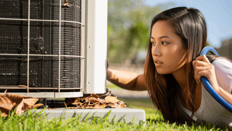 Homeowner inspecting a central AC condenser unit that is not cooling the house